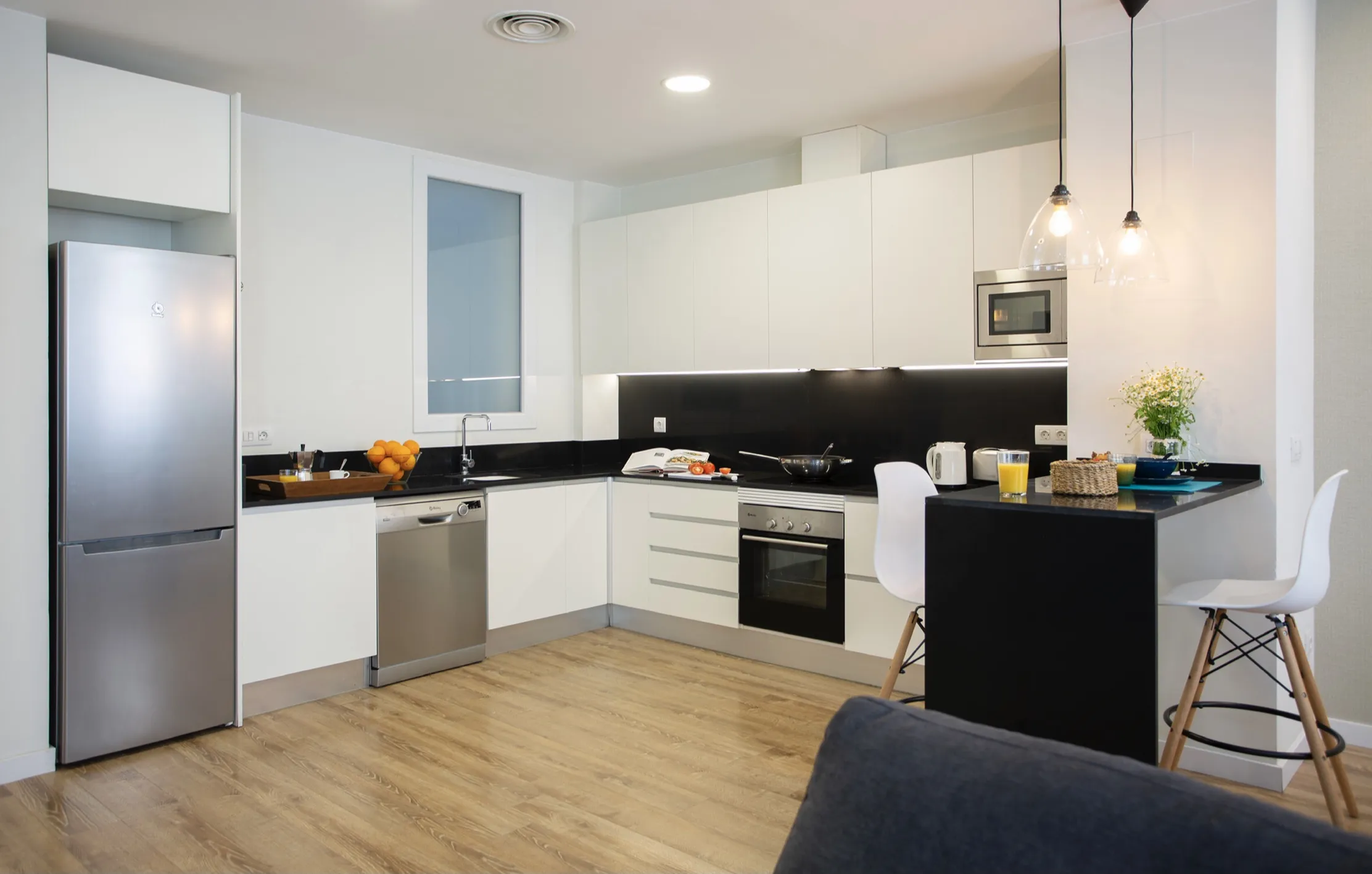 Living room of a DLS Spaces furnished apartment in Valencia with sofa, dining area and equipped kitchen